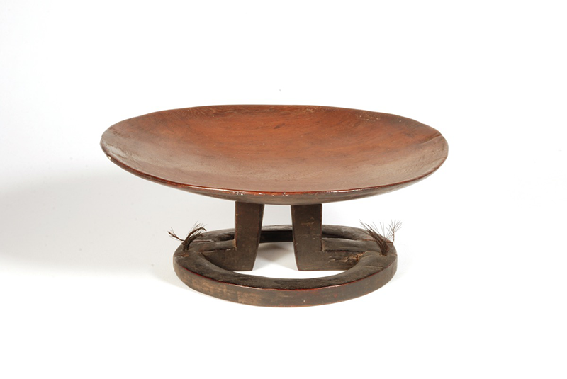Large flat round Yaqona dish in a reddish wood, with a rounded base. The legs to the base are stepped.
