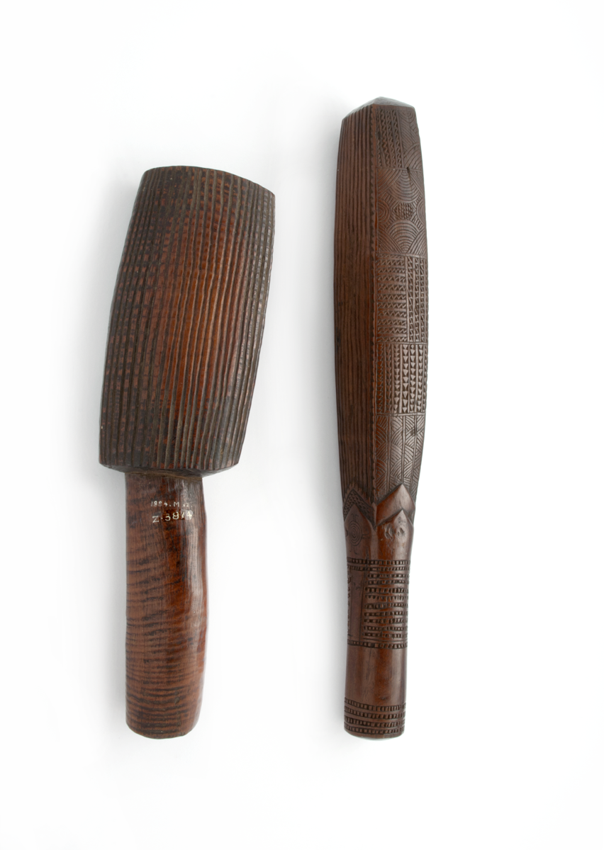 Two barkcloth beaters, made from wood, with engravings along them.