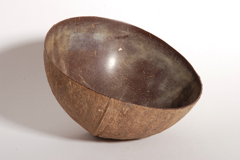 Simple half coconut cup that is polished inside. Shows signs of use. Mid-dark brown.