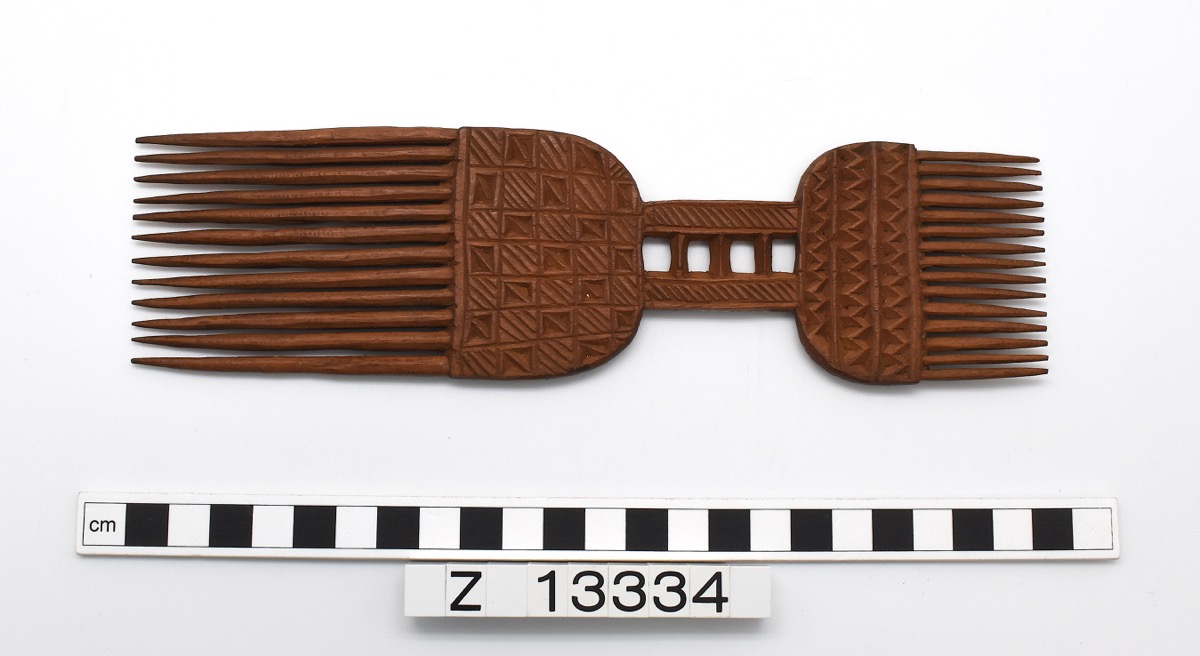 Double ended wooden comb, made up of two comb sections.