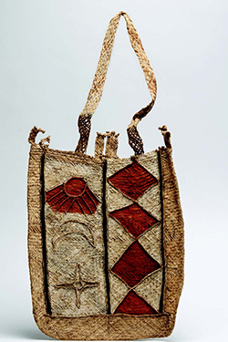 Handmade woven bag with red diamond detailing on the right hand side, and sun moon and star motifs on the left. A rectangular shaped bag with a long top handle