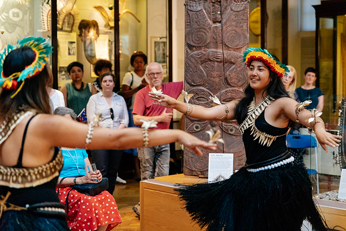 Women dressed in traditional pacific dress perform a dance in the MAA gallery.