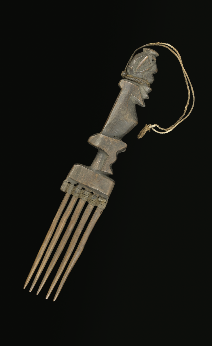  Oyiya or comb carved from wood. Handle carved like a seated human figure facing to the side; rectangular shoulder and six tapering prongs