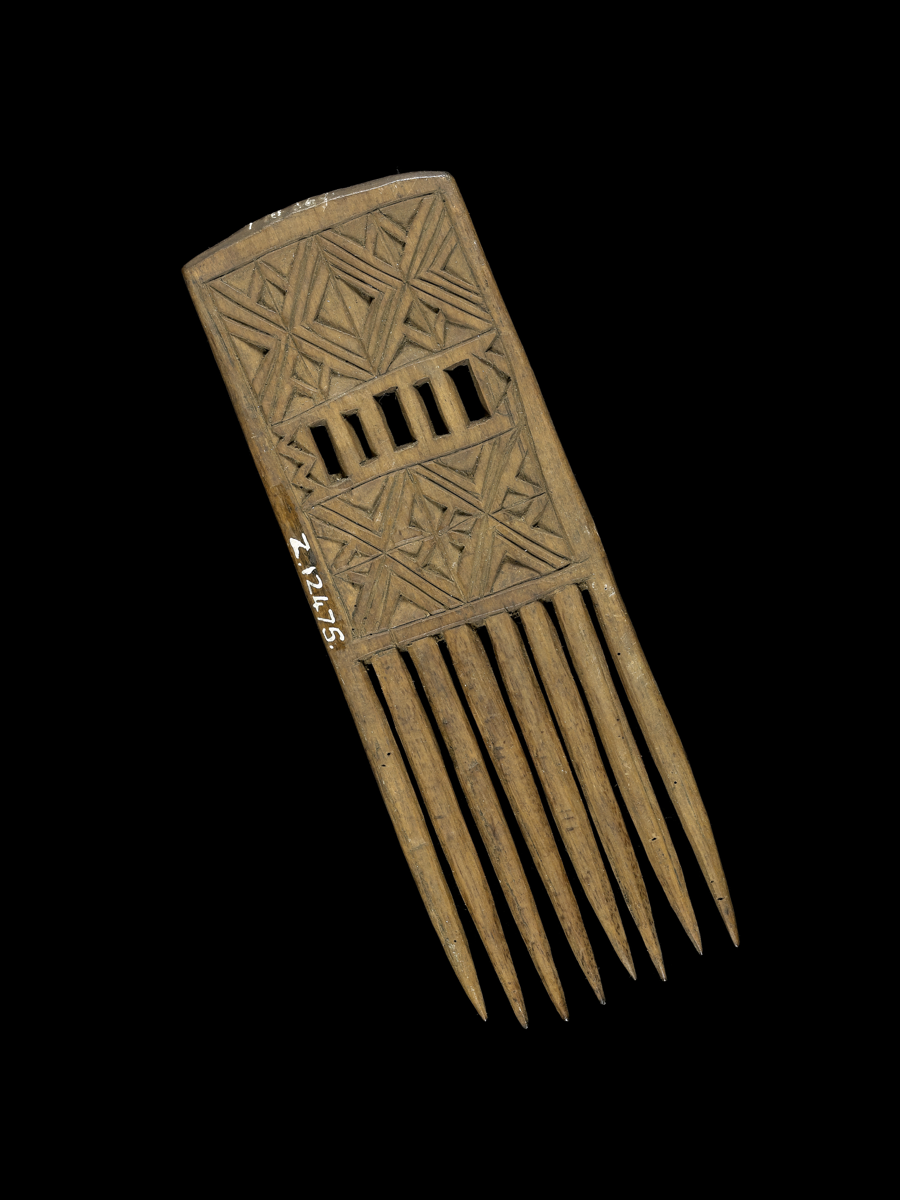 Carved wooden comb, with a rectangular handle. Five small rectangular cut-out sections with a geometric carved design.