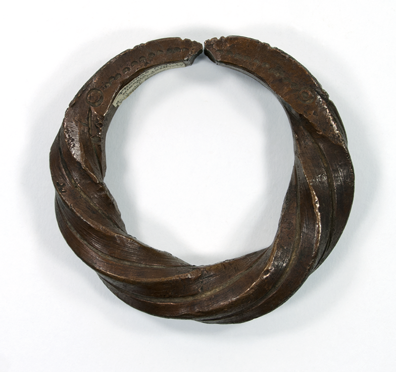  Bracelet, made of wrought copper brass, with a twisted design. It is open and has incised pattern near the closing.