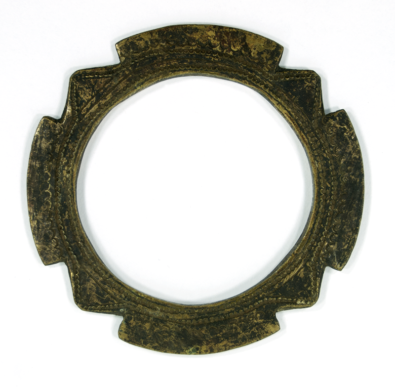 Bracelet of wrought brass, with jagged edge, and decorated with fine engravings on both sides.