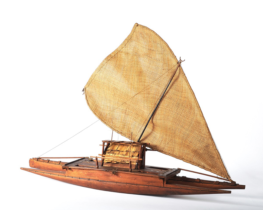 Double-hulled canoe with plaited pandanus sail and crescent-shaped mast head.