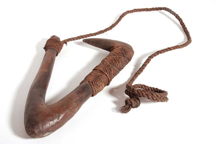 Very large fish-hook of wood in two pieces. The shank is made from a thick piece of curved dark wood. The point is also made of wood and curves inwards almost horizontally. 
