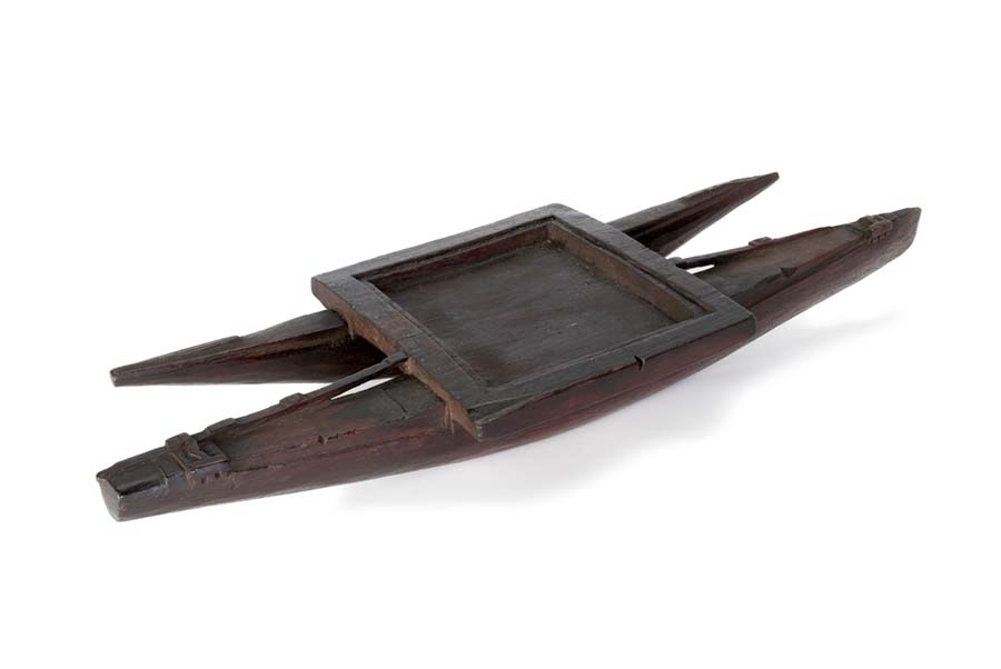  Canoe-shaped oil dish carved from a solid piece of dark wood.