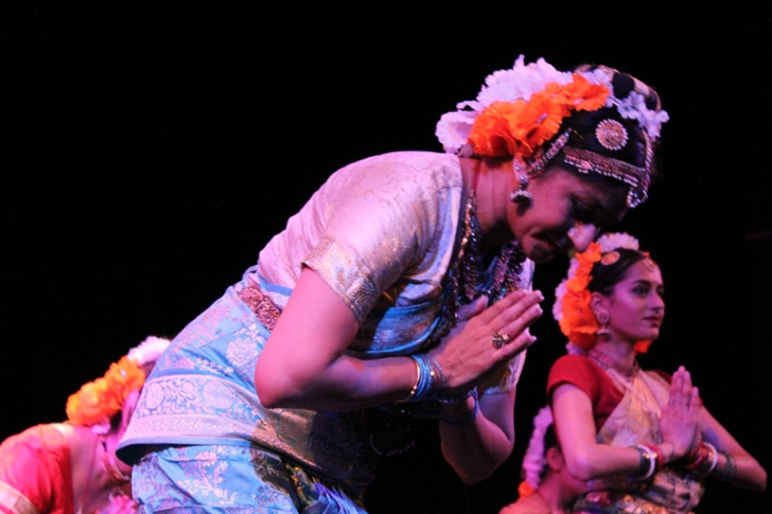 Dancers dressed in their costumes with their palms pressed together in front of their chests. The dancer in the foreground is bowing.