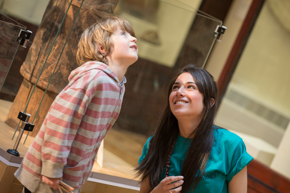 A museum staff member and visitor look at an exhibit