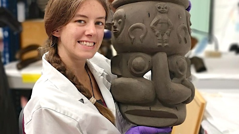 Photograph of Lily Stancliffe, smiling and holding a large clay pot.