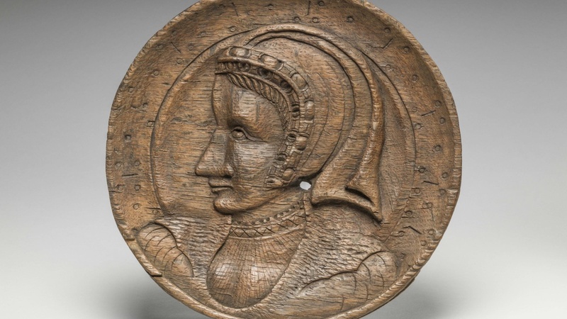 One of a pair of oak roundels, depicting the head of a woman in profile carved in low relief