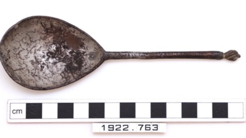 A metal spoon with a fig-shaped bowl which retains fragments of gilding.