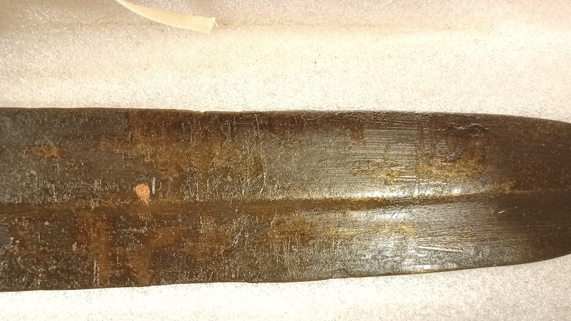 Detail of a section of a double edged blade with a greasy coating on its surface.