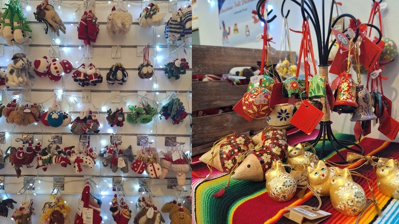 On one side are a range of felt animal decorations hanging on the wall and on the other are hand painted decorations including baubles, bells, and cand cats.