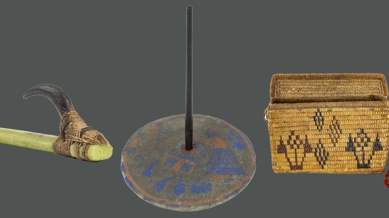 Three objects on a grey background. A fishing hook with a green shank, a spinning top with a pole emerging from the centre and a design in blue featuring a female figure, and a rectangular shaped handbag woven from plant fibre with a red strap.