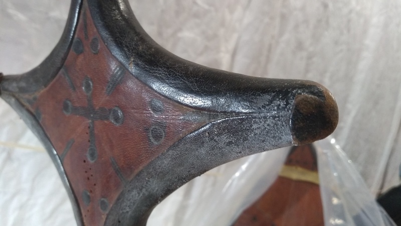 Detail of an upright cross-shaped section of a leather saddle, the surface of which is covered with a fine powder.