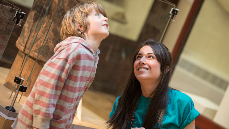 A museum staff member and visitor look at an exhibit