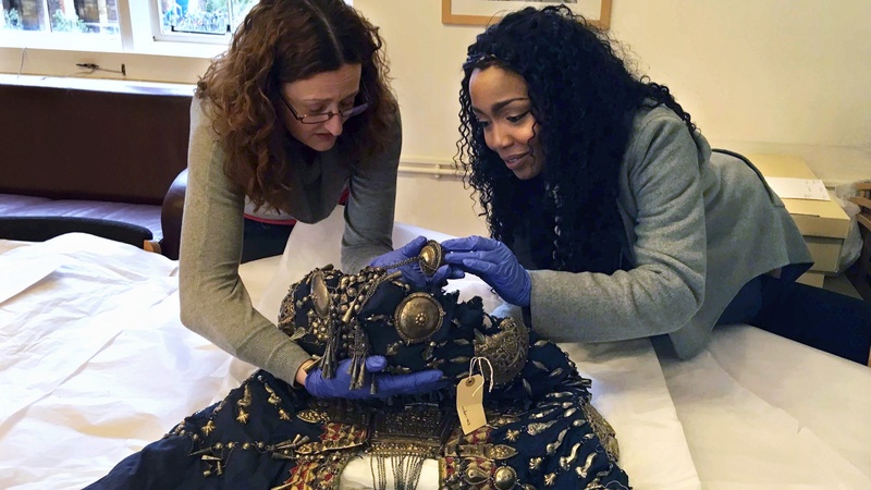 Researcher Vicky Ngari Wilson and Collections Manager for Anthropology Rachel Hand examining the robe of Abyssinian Queen Woyzaro Terunesh