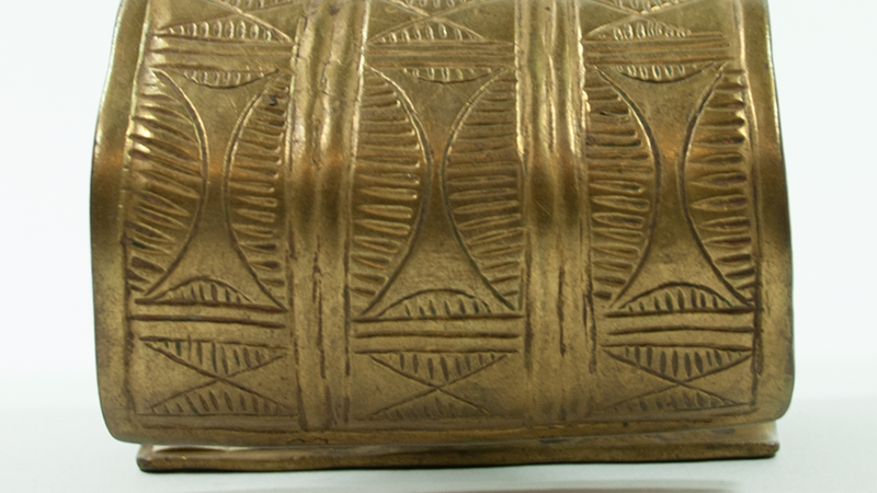 Wide, wrought brass bracelet with three strips of similar pattern.