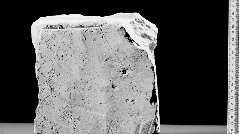 Piece of clunch on which is engraved about half the head of an Early Decorated six light window.