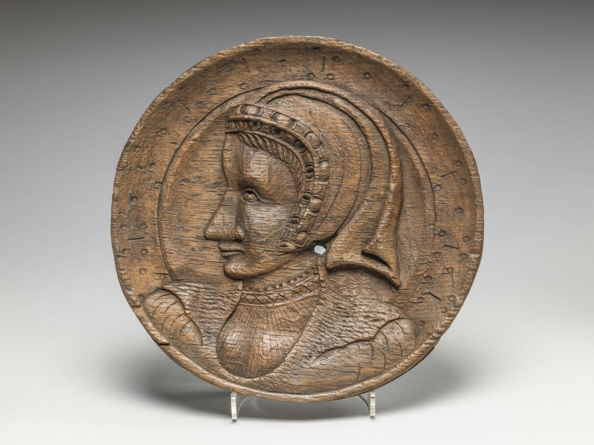 One of a pair of oak roundels, depicting the head of a woman in profile carved in low relief