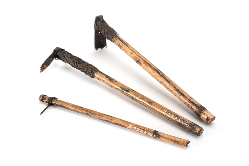 Three tools with varying chiselled heads, made of bamboo and metal tied at top.