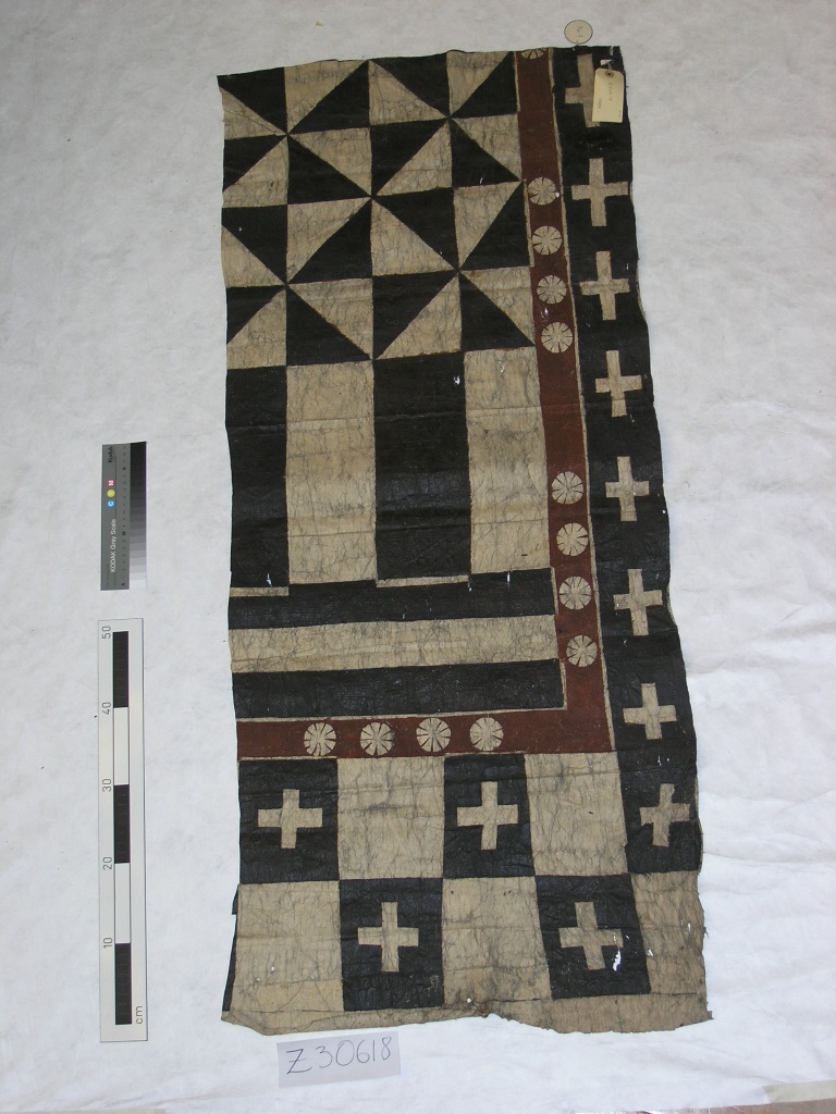 Partial piece of barkcloth with a distinctive design, in white, black, and red-brown. 