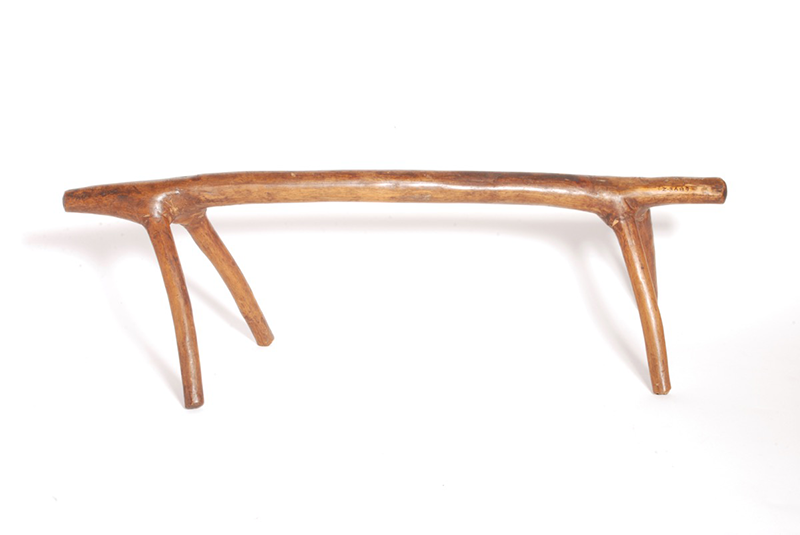 Light wood headrest made of a single piece of wood. Slightly resembles antlers in the design, and slants slightly to the right.