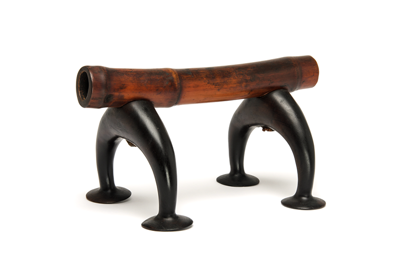 Headrest with two rich dark brown feet, curved, and a reddish-brown wooden stand.