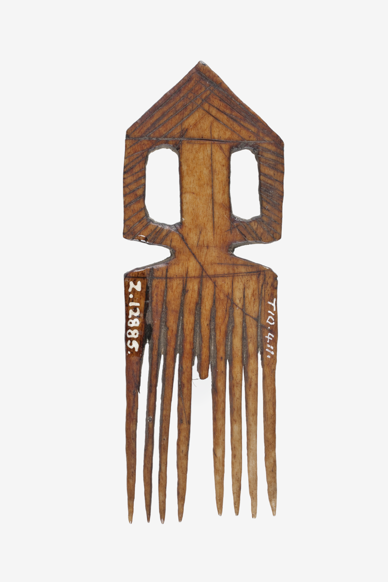 A small comb with nine prongs and decorated handle.