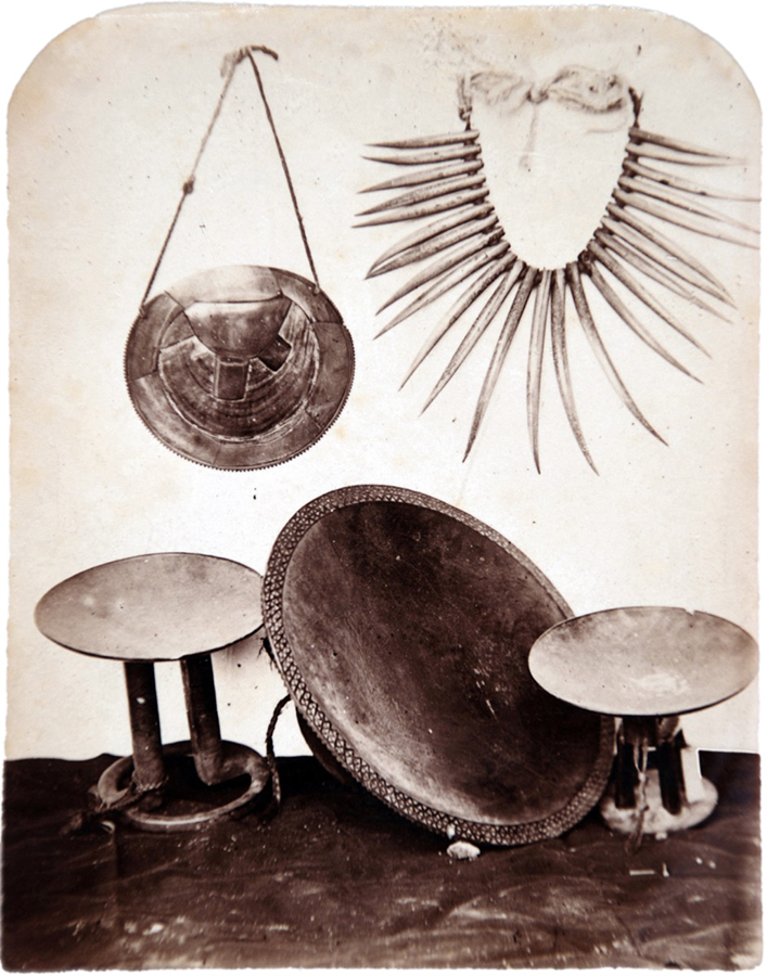 Photograph of five artefacts, including a breastplate, necklace, and three yaqona dishes, arranged against a white backdrop.