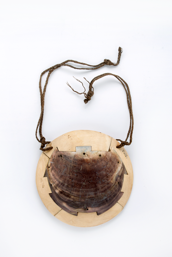 Large circular breastplate made from four curving sections of whale tooth/ivory with a central section made from a large piece of black-lipped oyster shell, turtle-shaped. 