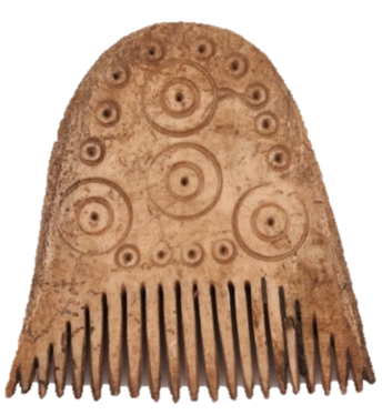 A rounded bone comb with narrow teeth. The body of the comb has circular detailing, smaller at the edge then four large circles interspersed throughout.