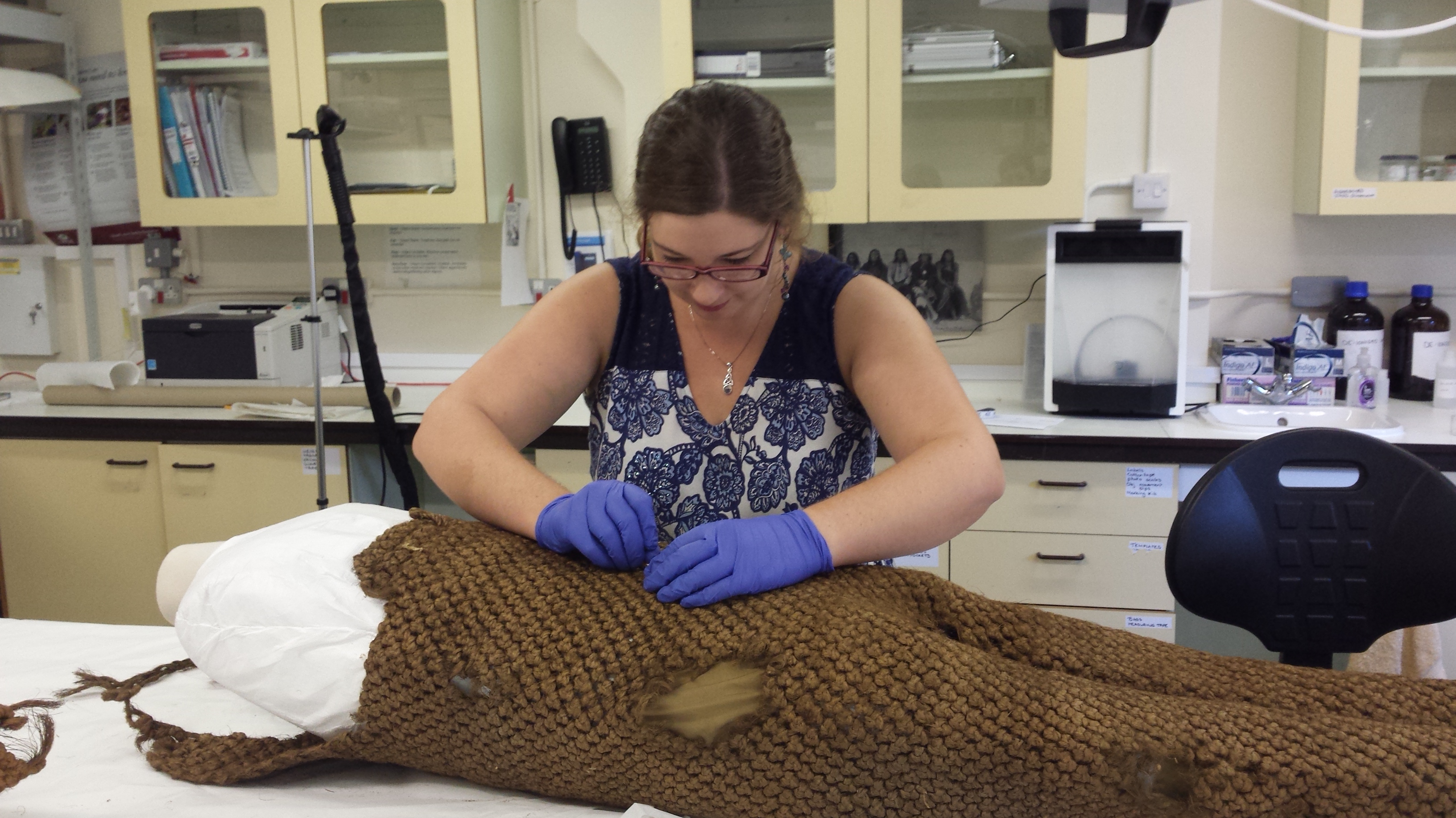 Conservator Rachel Howie conserving woven overalls from Kiribati