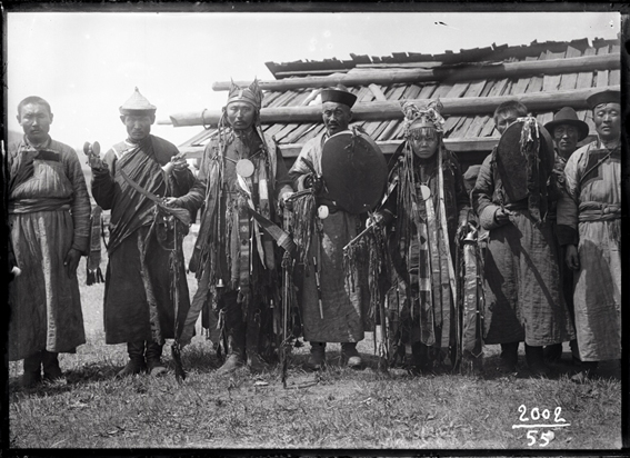 A black and white photo of  “A shaman, a shamaness, and a Achinsk Lama with their helpers.”