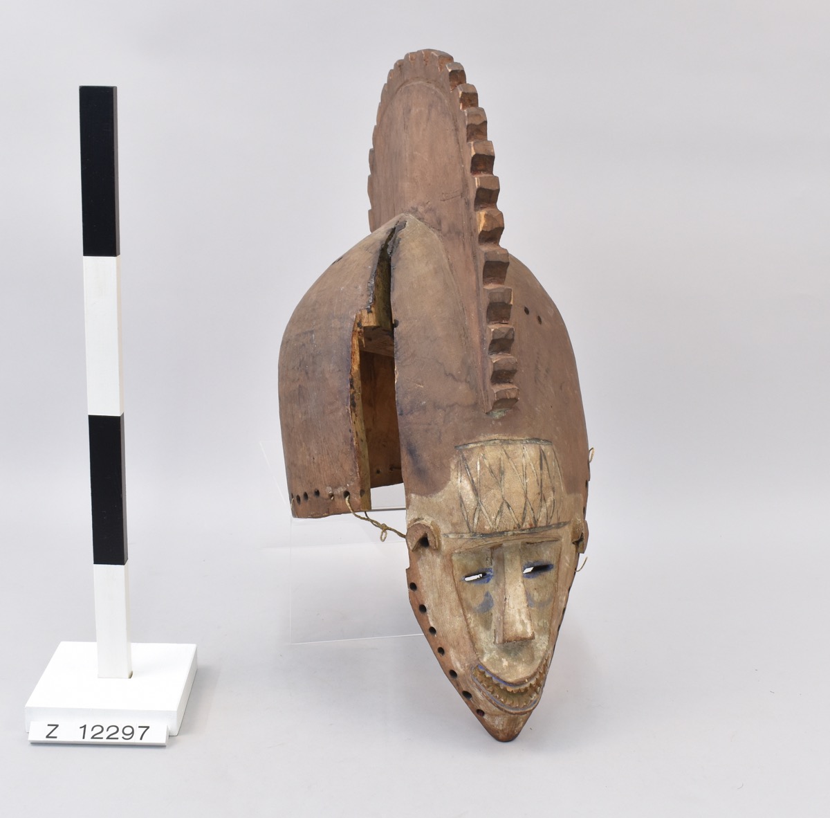 Obo or wooden helmet mask. Small face has narrow eye slits, cheeks and mouth decorated with blue