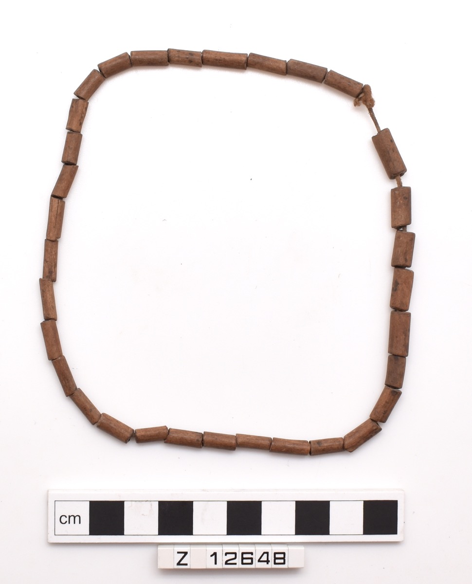 Necklace of mid brown rectangular (circular) beads, strung onto cotton. Short-medium length.