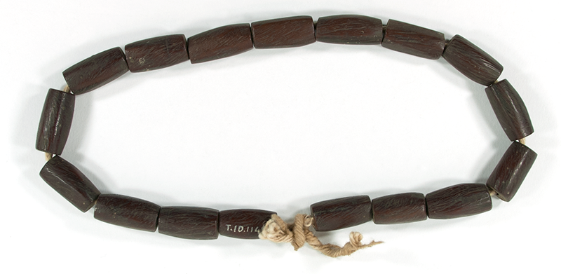 Necklace made from 27 cylindrical bone beads dyed a reddish-brown and strung on fibre. The beads are rounded at the edges. Short in length; choker-length.