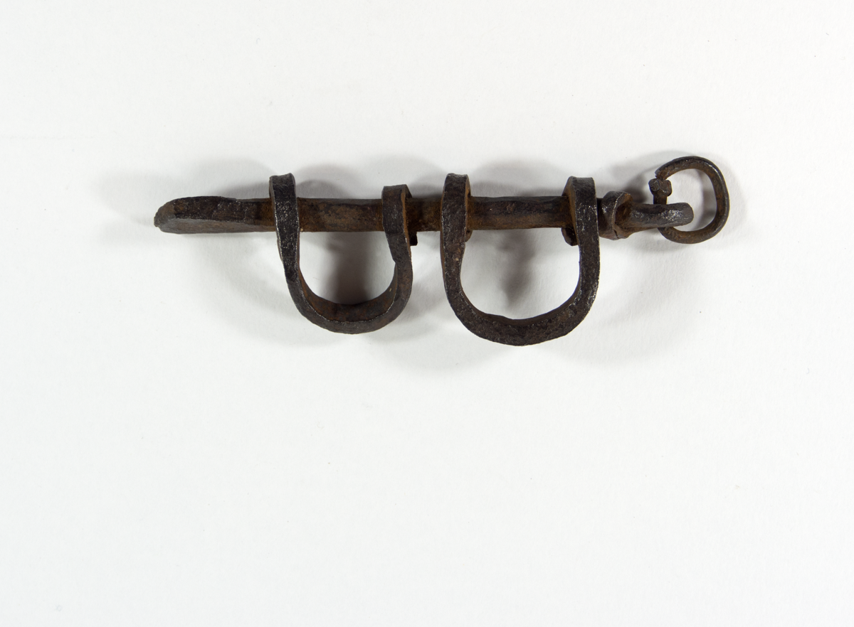 Small iron charm shaped like shackles.