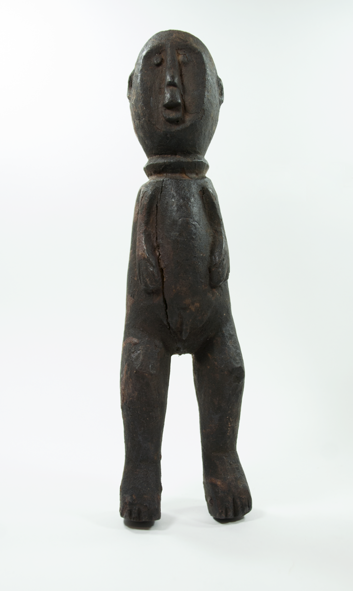 Standing male figure carved from wood. Hands on belly, legs slightly bent; carved ring around the neck.
