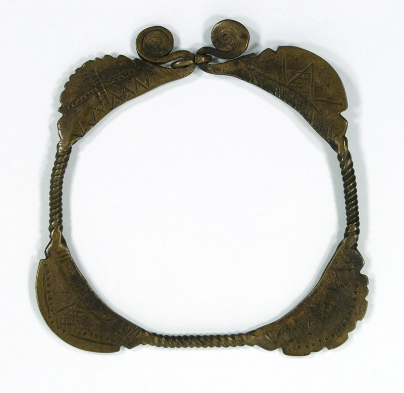 Flat brass bracelet closed with a link. The decoration is similar on each side, but more elaborate on one.