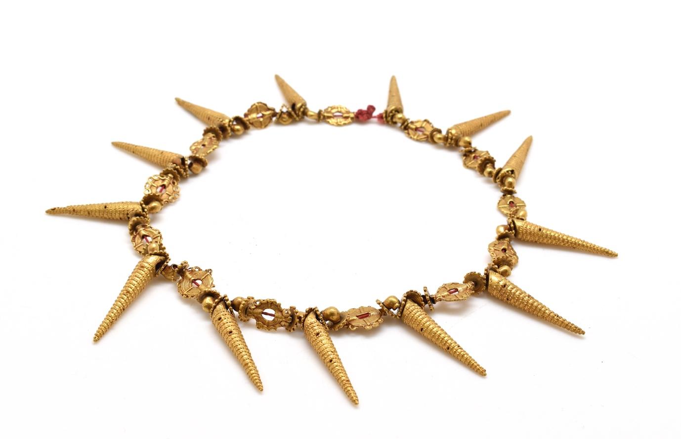 Golden necklace with red beads.